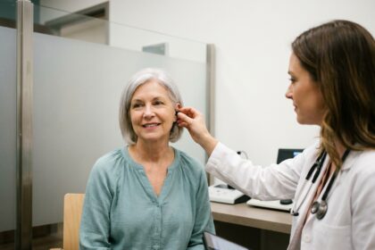 Femme âgée lors d'un bilan auditif avec une audiologiste en cabinet médical